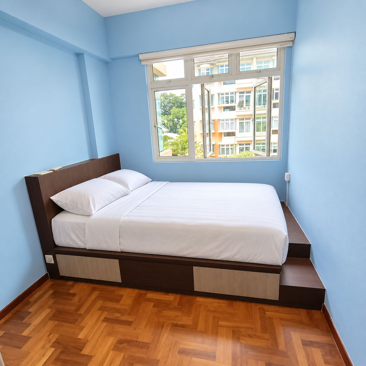 Straight-on view of the dark walnut platform bed with white bedding, cream drawer fronts and sky-blue walls